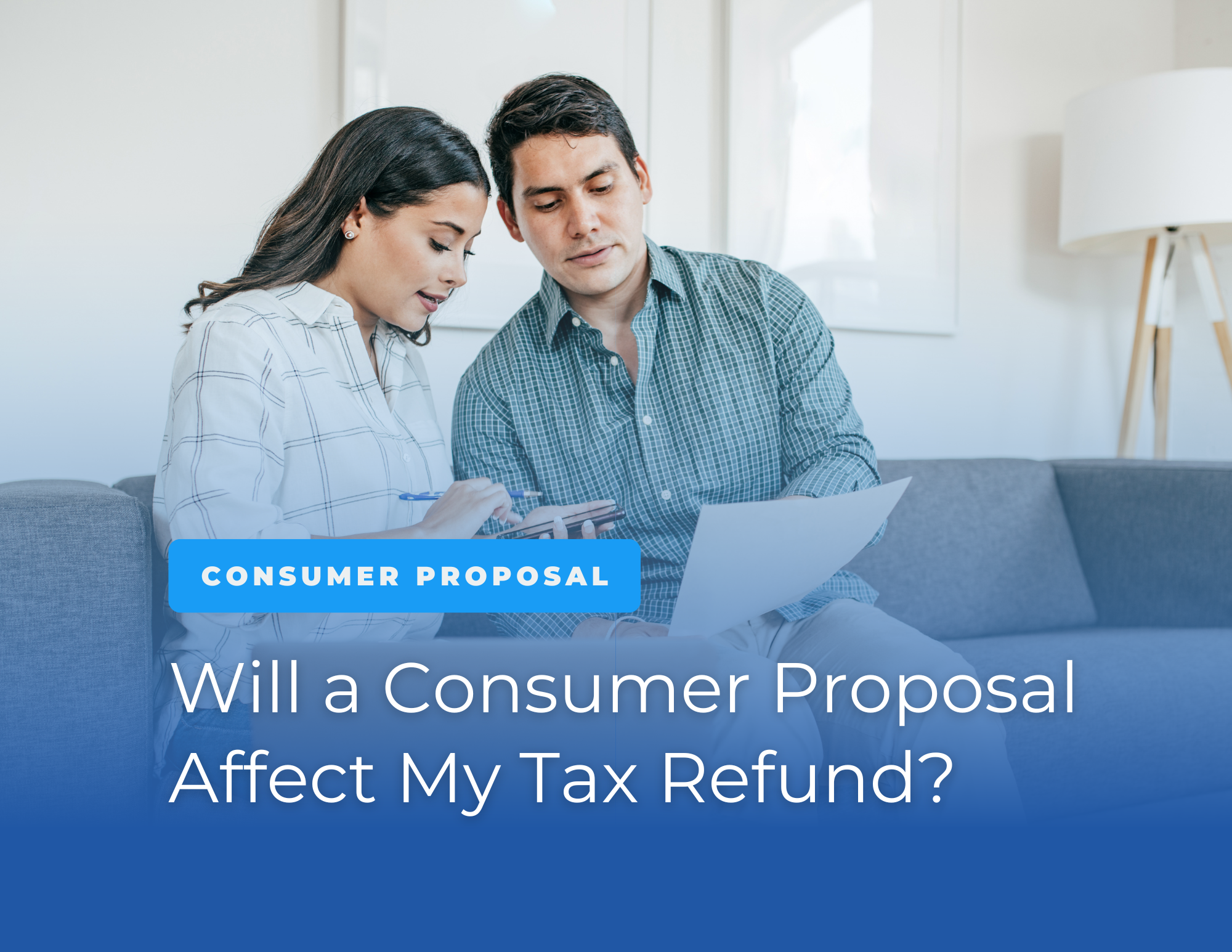 a couple sitting together on a couch reviewing tax documents with a calculator